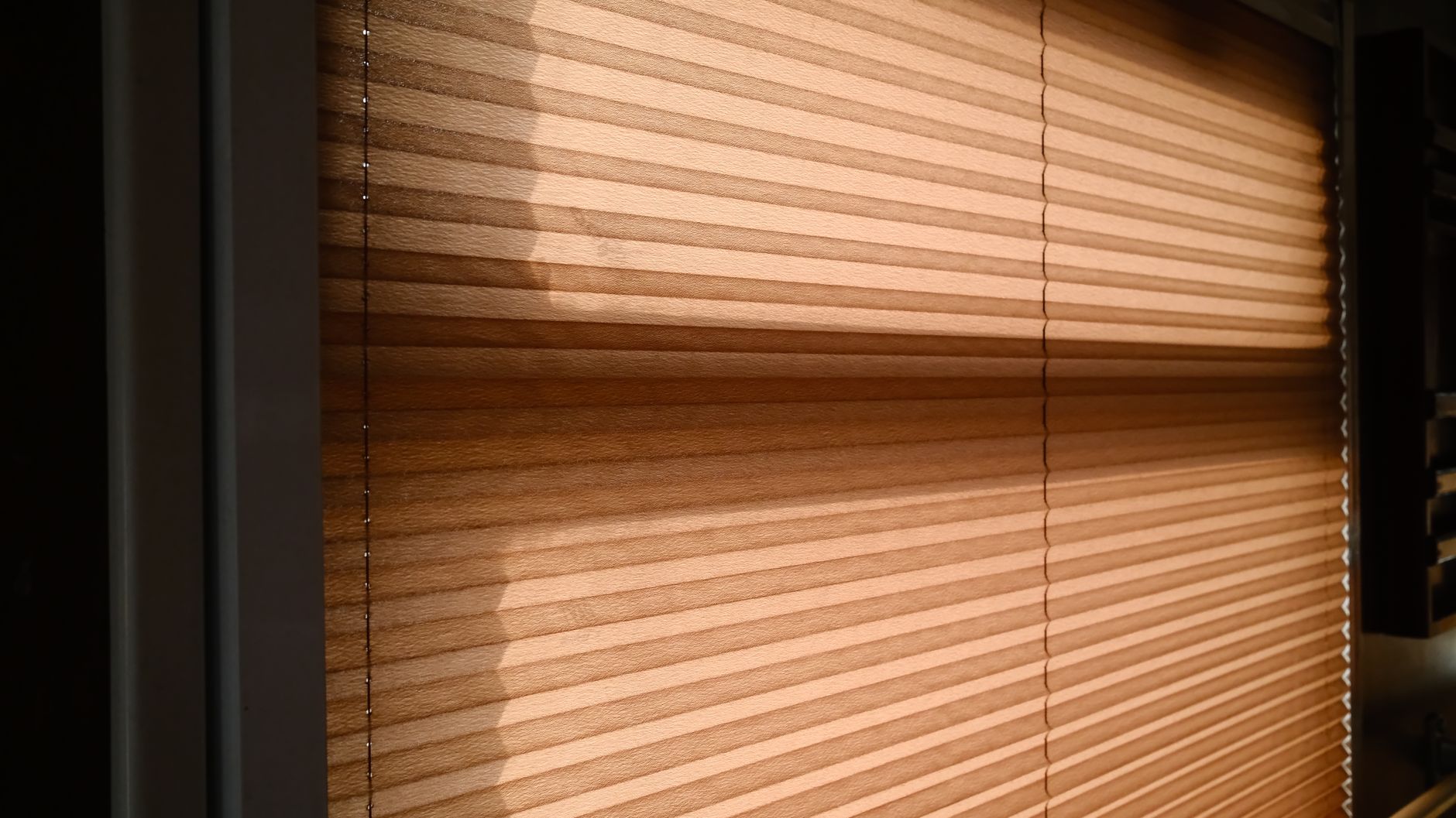 warm sunlight casting shadows on window blinds